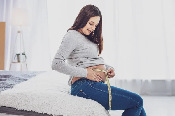 Charming future mother measuring her belly — Stock Photo, Image