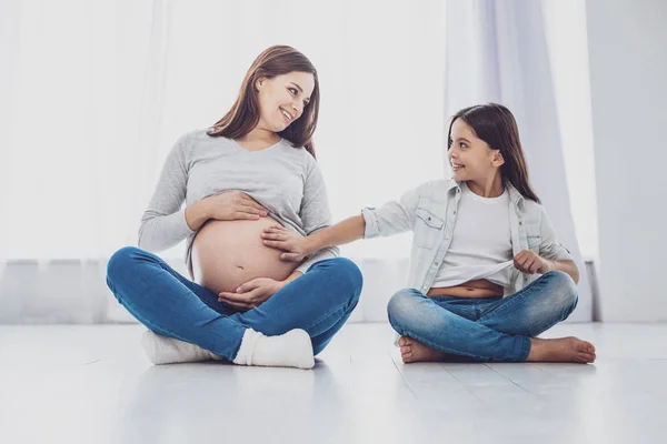 Longitud completa de la madre embarazada positiva con su hija pequeña — Foto de Stock