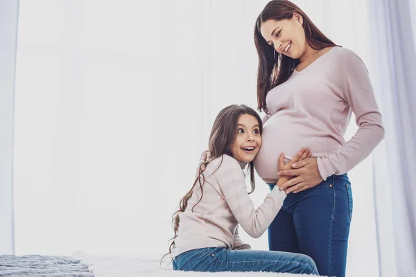 Sonidos Asombrosos Sorprendida Niña Alegre Tocando Vientre Sus Madres Mientras — Foto de Stock