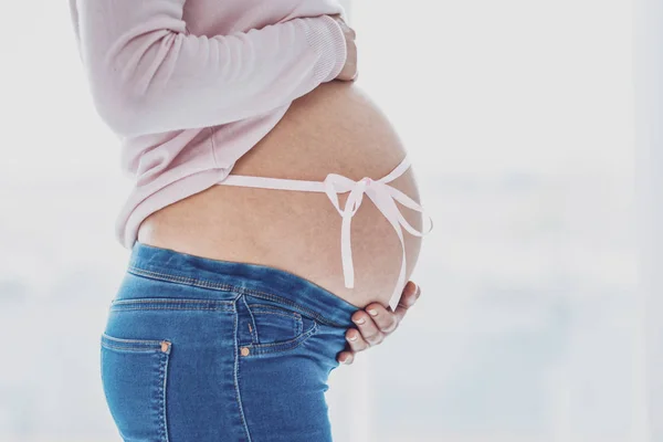 Profil av gravid kvinna som håller henne magsäck — Stockfoto