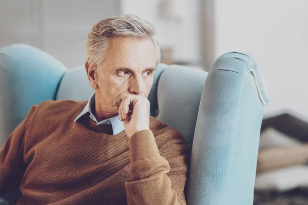 Crear un plan. Hombre alegre sentado en el sillón y mirando a un lado — Foto de Stock