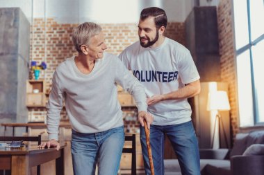 Hoş güvenilir gönüllü emekli destekleyen ve gülümseyen.