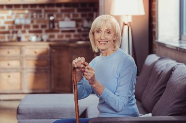 Oturma ve gülümseyen memnun hoş kadın.