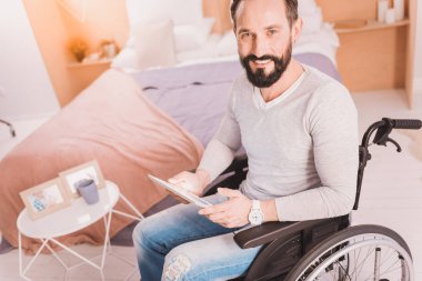 Orta yaşlı gülümseyen Engelli adam evde istirahat