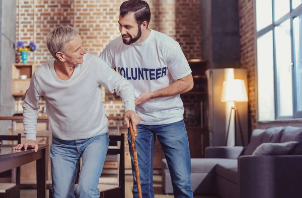 Attente voorzichtig man glimlachend en ondersteuning van een gepensioneerde. — Stockfoto