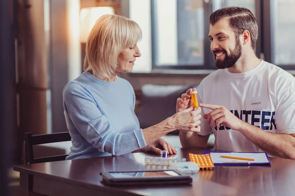 Intresserad av senior kvinna tittar på piller och lyssna. — Stockfoto