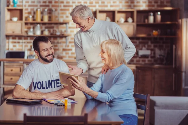 Senior interesse man permanent en praten met een vrijwilliger. — Stockfoto