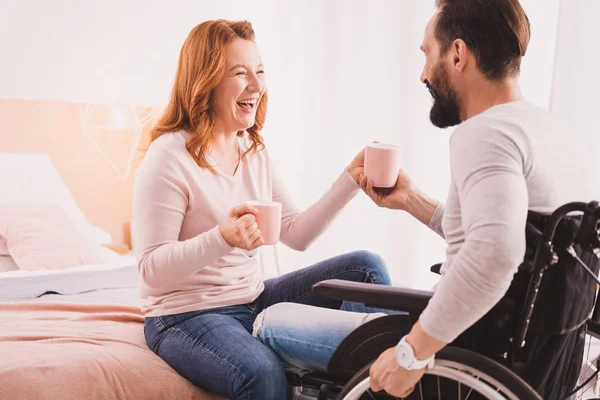 Mujer feliz bebiendo té con su marido discapacitado — Foto de Stock