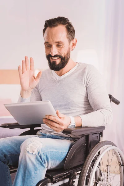 Alegre hombre con ruedas uisng una tableta para la comunicación — Foto de Stock