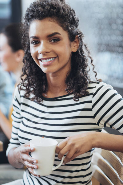 Glad enthusiastic woman drinking coffee