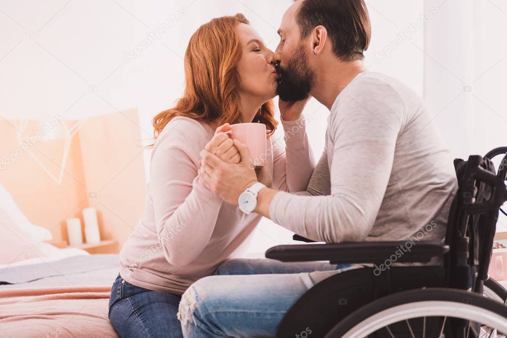 Mid aged loving couple kissing at home