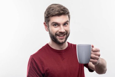 Sakallı yakışıklı mavi bardak taze demlenmiş kahve ile tutarak