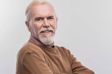 Yaşlı mavi gözlü giyen koyu kahverengi süveter geniş gülümseyen adam