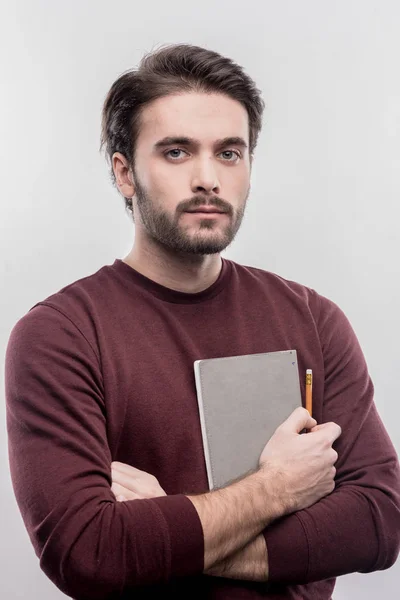 Serious handsome office manager holding notebook and pencil