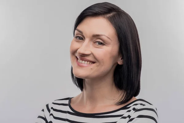 Dark-haired cute woman with facial wrinkles smiling broadly — Stock Photo, Image