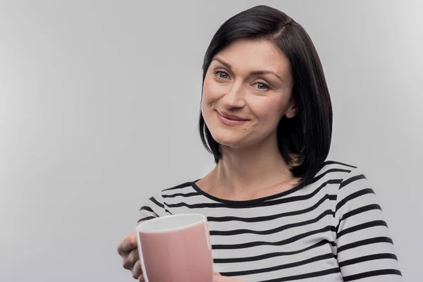 Dark-haired vrouw biedt kopje thee haar liefhebbende echtgenoot zorg — Stockfoto