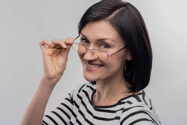 Mature dark-haired woman with facial wrinkles smiling broadly — Stock Photo, Image