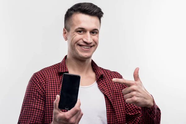 Jovem feliz sentindo-se feliz segurando seu novo telefone inteligente preto — Fotografia de Stock