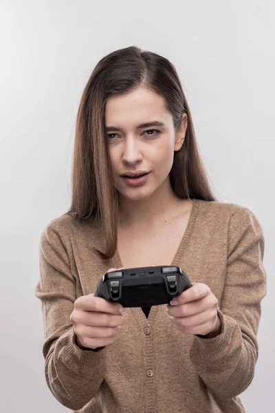 Mujer guapa de ojos oscuros sintiéndose serio mientras juega videojuego — Foto de Stock