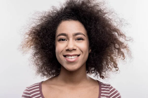 Dark-eyed curly woman smiling broadly while feeling very cheerful — Stock Photo, Image