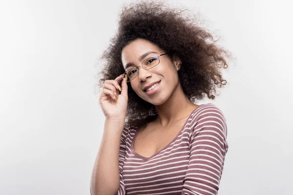 Beautiful curly dark-haired office worker wearing glasses smiling broadly — Stock Photo, Image