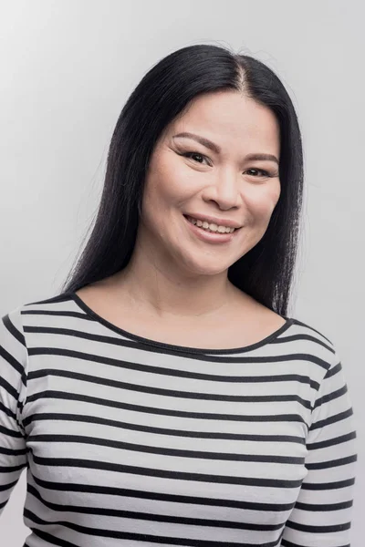 Mujer sonriente de cabello oscuro con camisa a rayas en blanco y negro — Foto de Stock