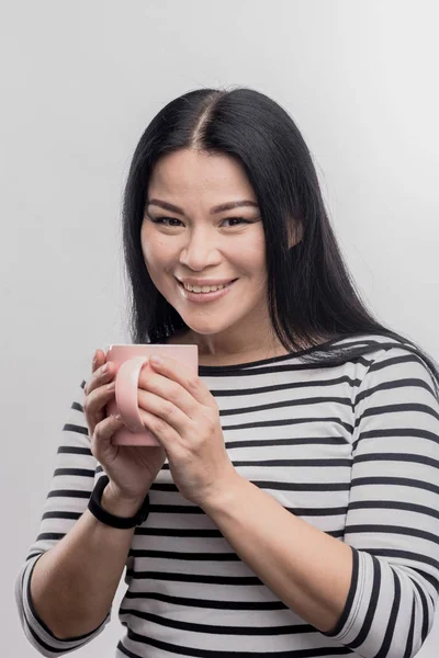 Radiante hermosa mujer de pelo oscuro beber té delicioso caliente — Foto de Stock