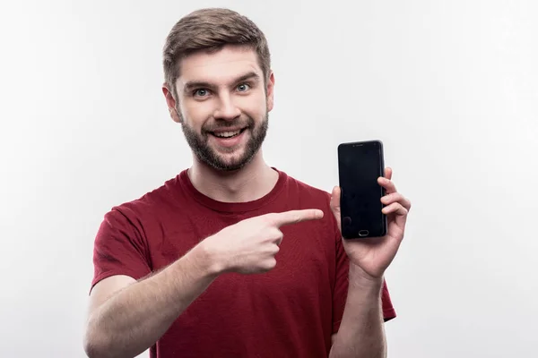 Homem de negócios barbudo de cabelos escuros segurando seu novo telefone inteligente — Fotografia de Stock