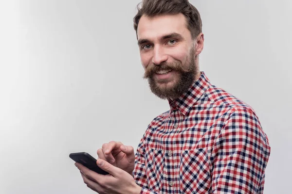 Homem barbudo de olhos azuis, levando seu telefone preto por ligar para sua esposa — Fotografia de Stock