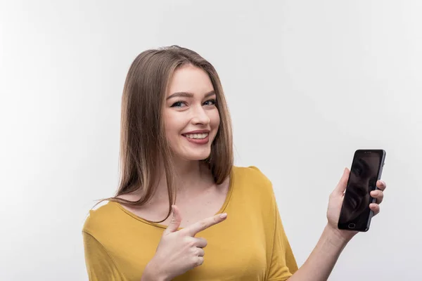 Sorrindo loira de cabelos compridos mulher segurando seu telefone enquanto chama amigos — Fotografia de Stock