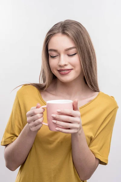 Donna attraente con lunghi capelli biondi in possesso di tazza con tè gustoso — Foto Stock