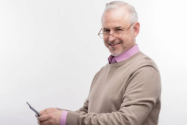 Smart dark-eyed elderly university professor using his smart phone