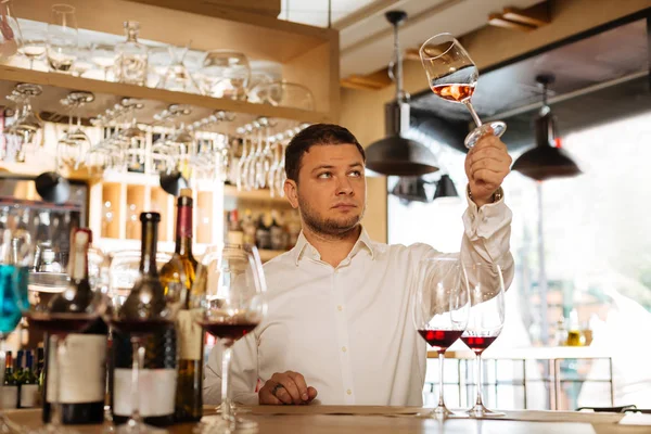 Nice smart man looking at the wine glass — Stock Photo, Image