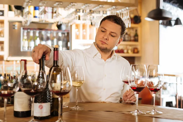 Hombre guapo serio tomando una botella de vino — Foto de Stock