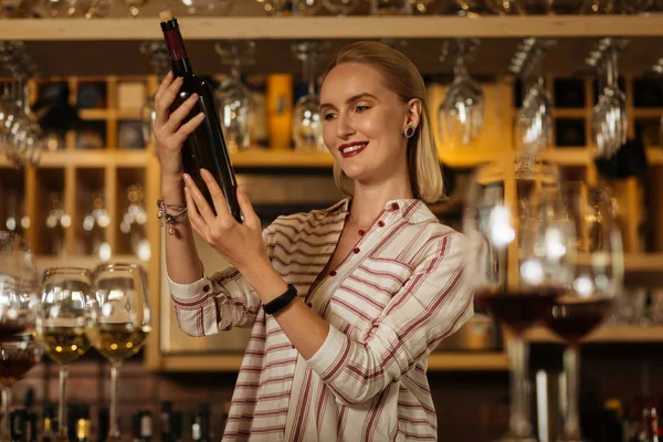 Vrolijke happy vrouw lezen het etiket van de fles — Stockfoto