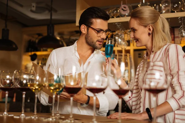 Bonito homem olhando para o copo com vinho azul — Fotografia de Stock