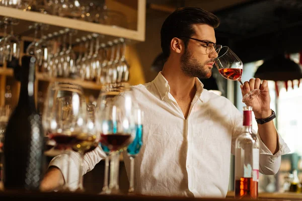 Hombre serio inteligente sintiendo el olor del vino — Foto de Stock