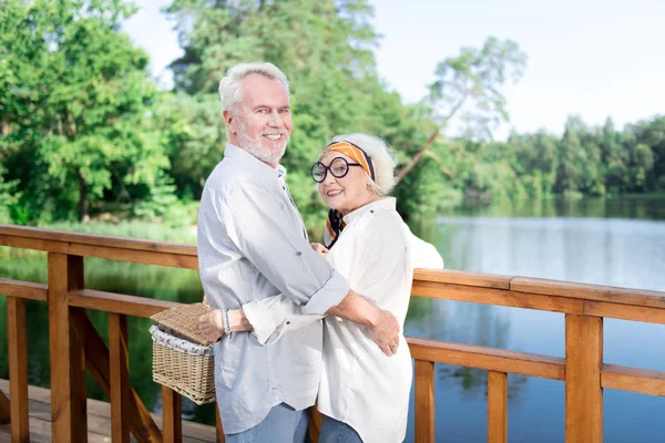 Dos jubilados radiantes sonriendo ampliamente sintiéndose emocionados por el picnic — Foto de Stock