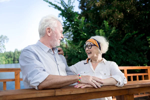 Gyönyörű nyugdíjas asszony nevetve férje vicceket hallgatni — Stock Fotó