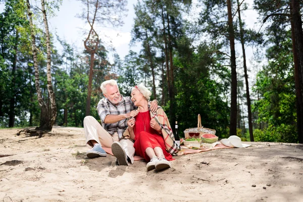 stock image Laughing pensioners having romantic picnic near the river