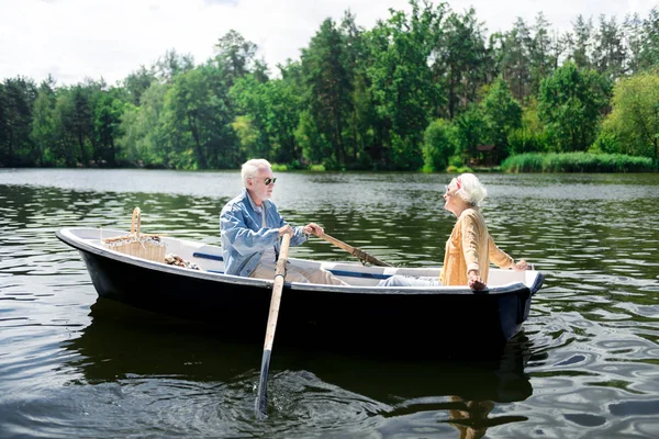 Elegante atraente esposa idosa sentando-se incrível no barco com o marido — Fotografia de Stock