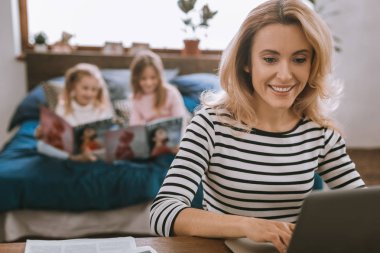 Onu laptop kullanan akıllı neşeli kadın