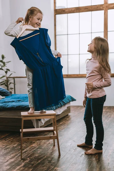 Encantada chica agradable sosteniendo un vestido — Foto de Stock