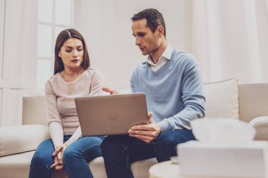 Dizüstü bilgisayar ekranında işaret eden güzel ciddi adam