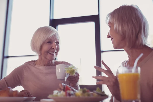 Vriendelijke mooie dame op zoek naar een andere vrouw en glimlachen. — Stockfoto