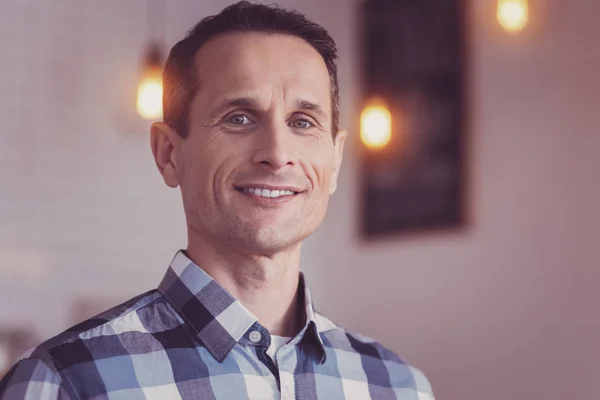 Handsome confident man smiling being In the bright room.