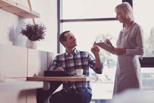 Camarero atento y agradable de pie y tomando notas . — Foto de Stock