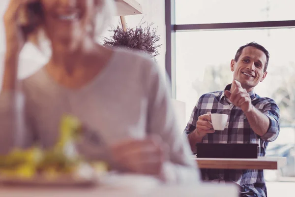 Inteligente hombre guapo sentado y señalando a un lado . — Foto de Stock