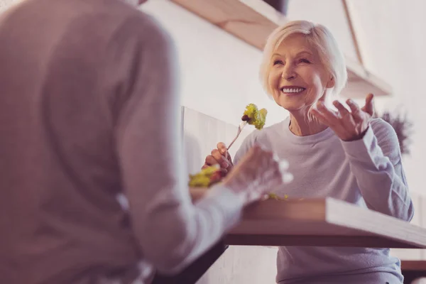 Senior söt kvinna ler och äta. — Stockfoto