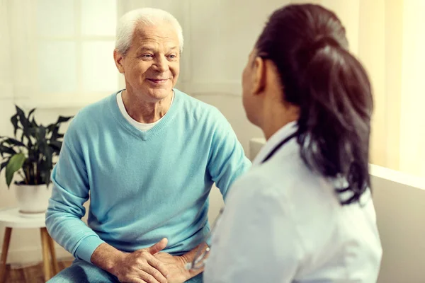 Homem idoso de mente positiva ouvindo enfermeira durante a consulta — Fotografia de Stock